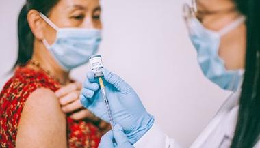 卫生保健提供者为一名成年妇女准备疫苗